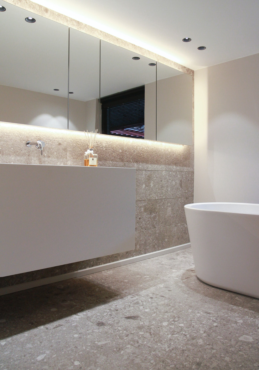 Zu sehen ist ein elegantes Designerbad mit weißem minimalistischen Waschtisch vom Schreiner nach Maß.